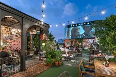 a patio at a restaurant with people sitting at tables at The Quartier Hotel Phromphong - Thonglor in Bangkok