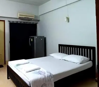 a bed with two pillows on it in a room at Jirapong apartment in Bangkok