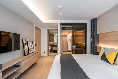a bedroom with a large bed and a tv at Destiny63 Ekamai Apartment in Bangkok