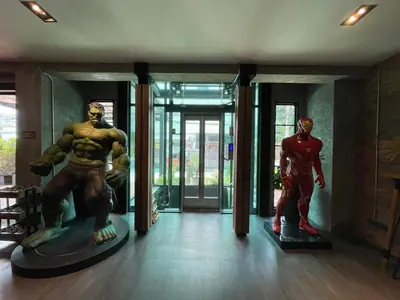 a room with statues of superheroes in front of a building at Loft122 Hotel in Ban Zong Katiam