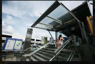 a woman standing on the stairs at a bus stop at T8 Guest House Don Mueang Challenger, Located in Bangkok in Ban Song Hong