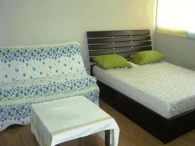 a bedroom with two beds and a bench in it at Thailand Taxiapartment Hostel, air conditioning and free Wifi in Thung Si Kan