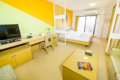 a large living room with a bed and a table at Sitara Place Serviced Apartment & Hotel in Bangkok