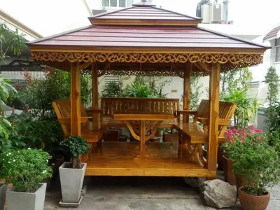 a wooden gazebo with a table and benches at Sitara Place Serviced Apartment & Hotel in Bangkok