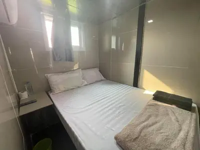 a small bed in a small room with a window at Charinsup Pinklao Hotel in Bang Kruai