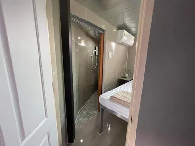 a bathroom with a walk in shower next to a walk in shower at Charinsup Pinklao Hotel in Bang Kruai