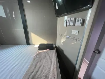a small room with a bed and a glass door at Charinsup Pinklao Hotel in Bang Kruai