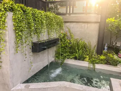 a water feature in a garden with a fountain at Exclusive access to the whole garden. in Bangkok