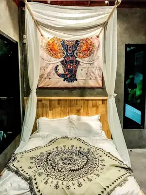 a bedroom with a bed with a painting above it at Exclusive access to the whole garden. in Bangkok