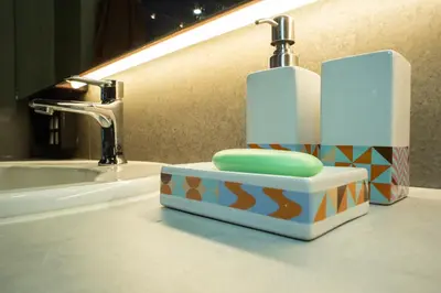 a bathroom sink with a toothbrush holder on a counter at Third Rock Hostel in Bangkok
