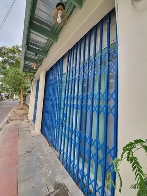 a building with blue glass doors on a street at บ้านอรุณHome in Bangkok