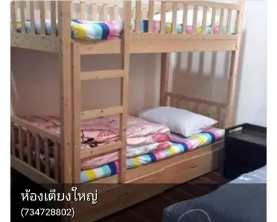 a wooden bunk bed with a bunk bedsheet at บ้านอรุณHome in Bangkok
