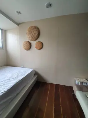 a bedroom with a bed and two baskets on the wall at บ้านอรุณHome in Bangkok