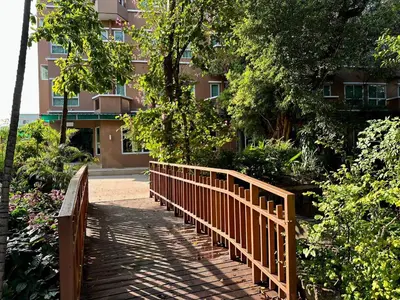 a wooden bridge in front of a building at Calypzo Bangkok in Bangkok