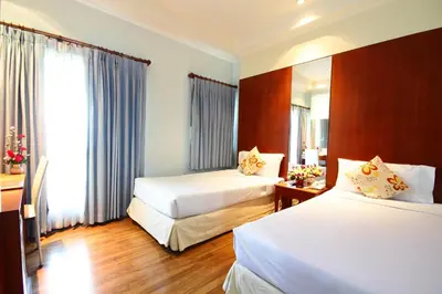 a hotel room with two beds and a window at Calypzo Bangkok in Bangkok