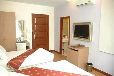 a hotel room with two beds and a television at Calypzo 2 Ratchada 20 in Bangkok