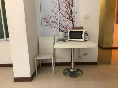 a table with a microwave and a chair on it at Calypzo 2 Ratchada 20 in Bangkok