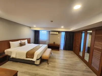 a hotel room with a large bed and a table at United Tower Thonglor by Aspira in Bangkok
