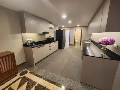 a kitchen with a vase of flowers on a counter at United Tower Thonglor by Aspira in Bangkok