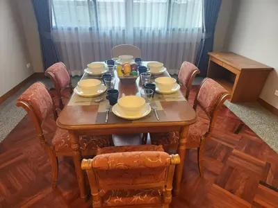 a dining room table with chairs and a table with dishes at United Tower Thonglor by Aspira in Bangkok