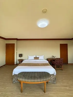 a large bedroom with a large bed and a bench at United Tower Thonglor by Aspira in Bangkok