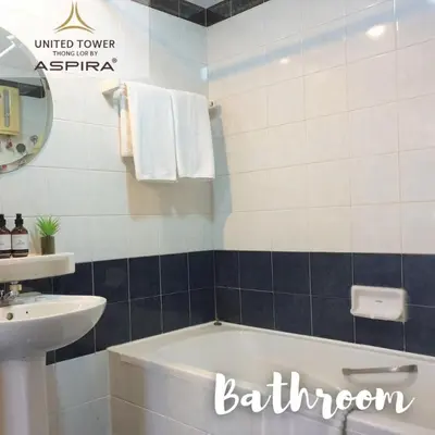 a bathroom with a tub and a sink at United Tower Thonglor by Aspira in Bangkok