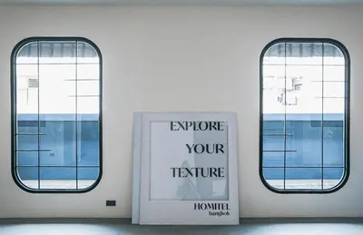 two windows in a room with a sign in the middle at HOMITEL Bangkok in Bangkok