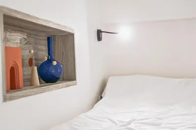 a bedroom with a white bed and a painting on the wall at HOMITEL Bangkok in Bangkok