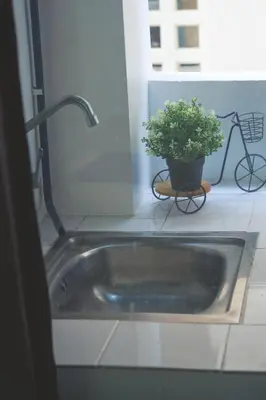 a sink in a bathroom with a potted plant at Baan Romdee in Nonthaburi