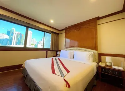 a hotel room with a large bed and a window at The Promenade Bangkok in Bangkok