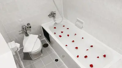 a bathroom with a toilet and a tub with hearts on it at The Promenade Bangkok in Bangkok
