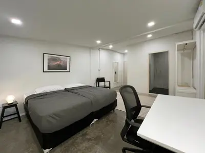 a bedroom with a bed and a table and chairs at Chatel Samyan - Self check-in in Bang Rak