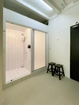 a bathroom with a shower and two tables in it at Chatel Samyan - Self check-in in Bang Rak