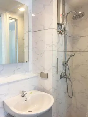 a white bathroom with a sink and a shower at Studio Nana by iCheck inn in Bangkok
