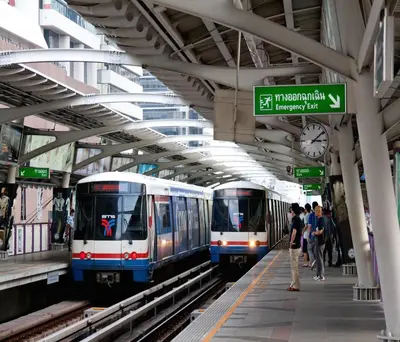 two trains in a subway station with people on the platform at Studio Nana by iCheck inn in Bangkok