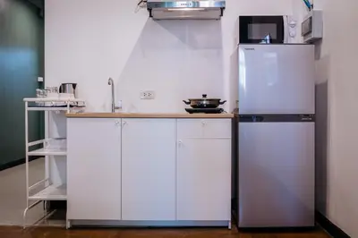 a kitchen with white cabinets and a refrigerator at T3 TWO Bedrooms WIFI Full kitchen 1 min to BTS in Bangkok