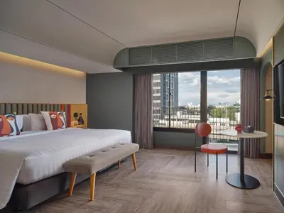 a bedroom with a large bed and a large window at The Quarter Onnut by UHG in Bangkok