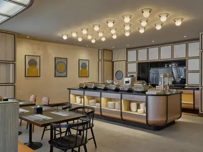 a restaurant with tables and chairs and a counter at The Quarter Onnut by UHG in Bangkok