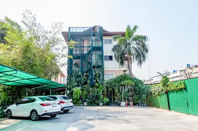 a white car parked in front of a building at The Palm Hotel in Salaya