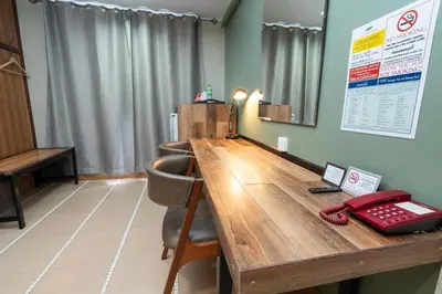 a conference room with a wooden table and a telephone at The Palm Hotel in Salaya