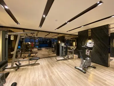 a gym with several treadmills and cardio machines at Politan Breeze, Chaophraya River view in Ban Sai Ma