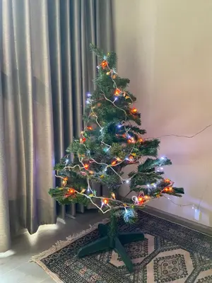 a christmas tree with lights in a room at Politan Breeze, Chaophraya River view in Ban Sai Ma