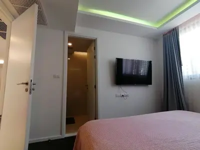 a bedroom with a bed and a television on the wall at Bangkok Asok Circle REIN Sukhumvit 12#2BR&3BR#Pool&Gym#Near Terminal 21 in Bangkok