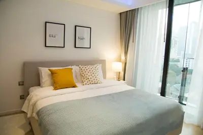 a bedroom with a bed with yellow pillows and a window at Sukhumvit 11#Luxury#Pool#Gym#BTS Nana&MRT Sukhumvit#1BR#Max4ppl in Bangkok