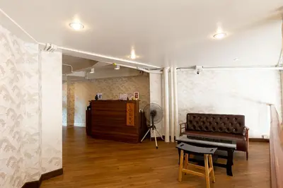 a living room with a piano and a desk at Loftel 22 Hostel in Bangkok