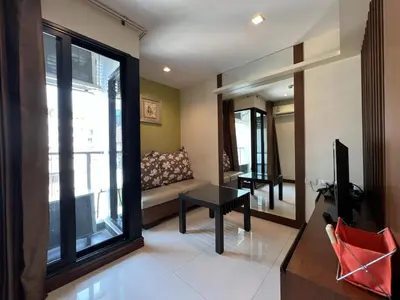 a living room with a couch and a large window at Silom Forest Exclusive Residence in Bangkok