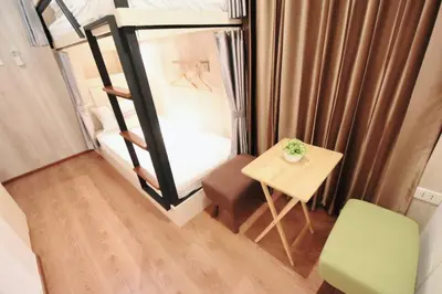 a small table and chair in a small room at Silom Forest Exclusive Residence in Bangkok