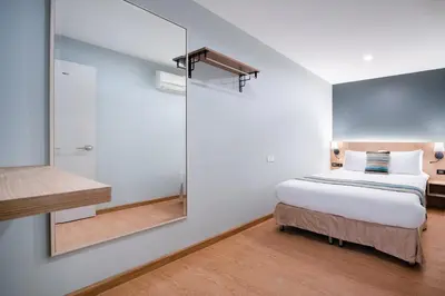 a bedroom with a bed and a large mirror at iCheck inn Residences Sathorn in Bangkok