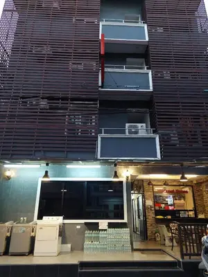 a tall building with a food court in front of it at BB GuestHouse in Ban Zong Katiam