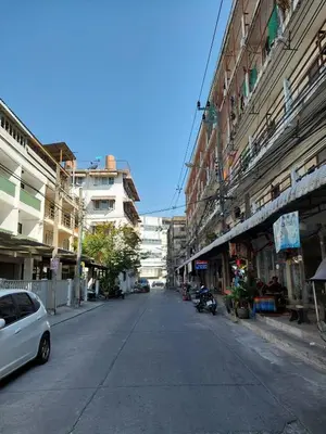 an empty city street with a white car driving down it at BB GuestHouse in Ban Zong Katiam